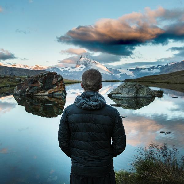 Man overlooking a mountain lake.